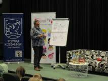 Pisarz Paweł Wakuła stoi na scenie w czasie spotkania