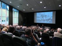 Tłumy publiczności na spotkaniu z Grzegorzem Śliżewskim. Autor siedzi na scenie z prowadzącym spotka