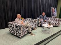 Pisarz Marek Stelar siedzi na scenie  z prowadzącym spotkanie
