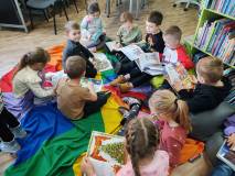 Dzieci przeglądają książki siedząc na podłodze