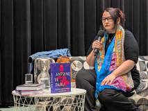 Pisarka Marta Orzeszyna siedzi na scenie w czasie spotkania autorskiego