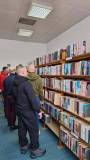 Panowie zwiedzają bibliotekę i oglądają nasz księgozbiór