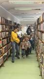 Bibliotekarka oprowadza dzieci po bibliotece.