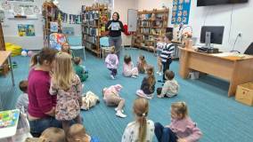 bibliotekarka pokazuje dzieciom ,,Mała Książka, Wielki Człowiek