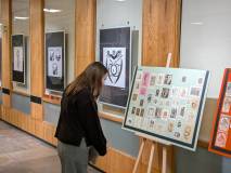 Uczestniczka po lewej przyglądają się wystawie archiwalnych ekslibrisów, przyklejonych do kartonowej