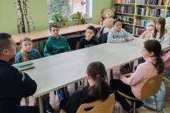 Policjant rozmawia z dziećmi o bezpiecznym zachowaniu w różnych sytuacjach