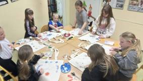 Uczestnicy zajęć przyklejają serwetki do swoich toreb