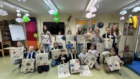 Dzieci razem z bibliotekarką prezentują swoje prace