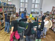 Dzieci chodzą wokół ułożonych w koło krzesełek 