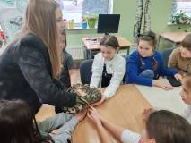 Prowadząca pokazuje dzieciom pytona królewskiego