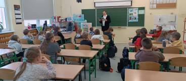 Bibliotekarka czyta książkę o pingwinach.