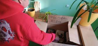 Uczestnik wkłada książki z selekcji do kartonu.