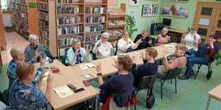 Uczestnicy spotkania rozluźniają palce przed ćwiczeniami jogi palców.