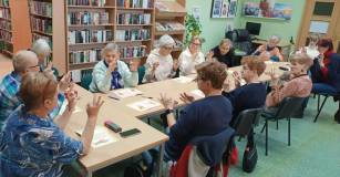 Uczestnicy spotkania ćwiczą mudry pod okiem prowadzącej.