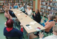 Uczestnicy spotkania ćwiczą mudry pod okiem prowadzącej.