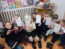 Dzieci pokazują kolorowankę dinozaura.