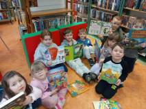 Przedszkolaki prezentują książki na temat dinozaurów.
