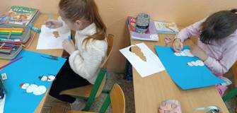Dzieci rysują i wycinają bałwanki.