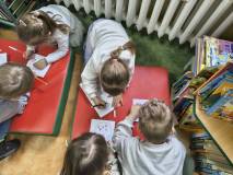 Przedszkolaki kolorują rysunek.