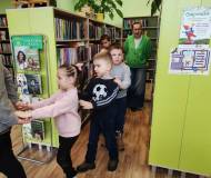 Grupa gęsiego przechodzi między regałami