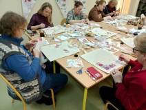 Uczestniczki warsztatów wycinają i przyklejają serwetki