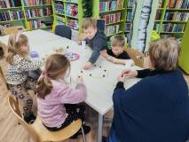 Bibliotekarka i czworo dzieci podczas gry w magnetyczne kamienie