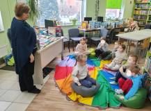 Niewielka grupa „Bystrzaków” z przedszkola Twoja Niania słucha bibliotekarki opowiadającej o kotach