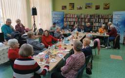 Rozmowy przy stole, w tle gra zespół muzyczny.