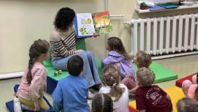 bibliotekarka czyta dzieciom książkę.