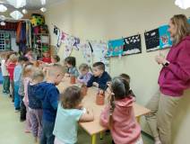 Dzieci wykonują prace plastyczne przy stolikach