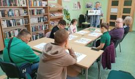 Wspólne czytanie przy stole książek o zwiastunach wiosny.