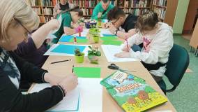 Na zdjęciu uczestnicy zajęć rysują elementy przebiśniegów potrzebne do stworzenia pracy plastycznej.