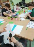 Na zdjęciu widać uczestników zajęć wycinających elementy potrzebne do wykonania pracy plastycznej pr
