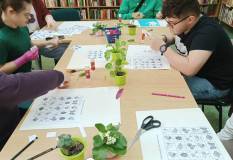 Na zdjęciu uczestnicy rozwiązują zadania edukacyjne na temat wiosny.
