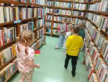 Dzieci szukają ukrytych zakładek między regałami