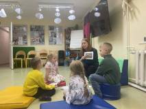 Bibliotekarka razem z dziećmi rozmawiają o zwiastunach wiosny