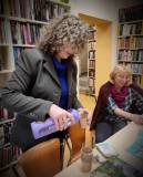 Pani Wiesława nalewa wodę wzbogaconą o minerały z butelki do papierowego kubka przy stole. Obok sied