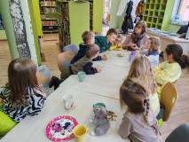 Dziewięcioro uczestników wraz z bibliotekarką gra w Gorącego ziemniaka