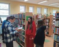 Bibliotekarka tłumaczy uczniom co to jest sygnatura i jak prawidłowo poukładać książki w działach.