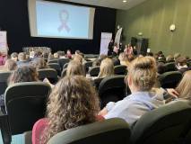 Zdjęcie przedstawia widok z tyłu na publiczność zgromadzoną w sali kinowej podczas wydarzenia edukac