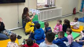Bibliotekarka czyta książeczkę dzieciom