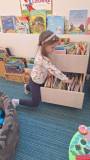 dziewczynka ogląda książki w bibliotece