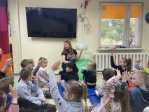 Bibliotekarka czyta książkę o wiośnie dzieciom 