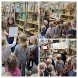 Książka w oprawie z metalu i zwój oraz zaciekawione przedszkolaki