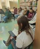 Uczniowie przeglądają książki, które maja włączyć do działów według sygnatury.
