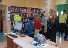 Bibliotekarka omawia proces wypożyczania książek i pokazuje, według jakich zasad ustawione są książk