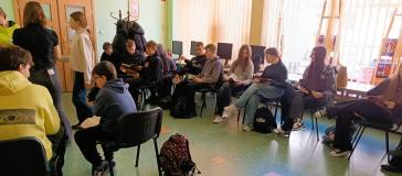 Uczniowie przeglądają książki, które maja włączyć do działów według sygnatury.