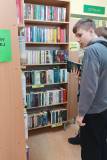 Uczniowie włączają na półki książki z działu Literatura polska.