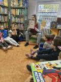 Bibliotekarka prezentuje przedszkolakom książkę pt.