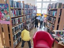 Dzieci szukają w bibliotece między regałami oznak wiosny